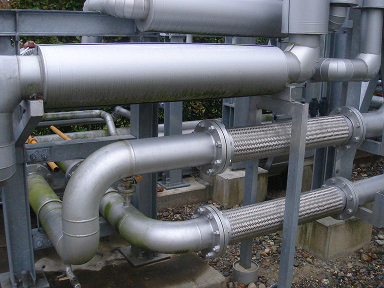 Placement of buried piping above ground and introduction of flexible piping